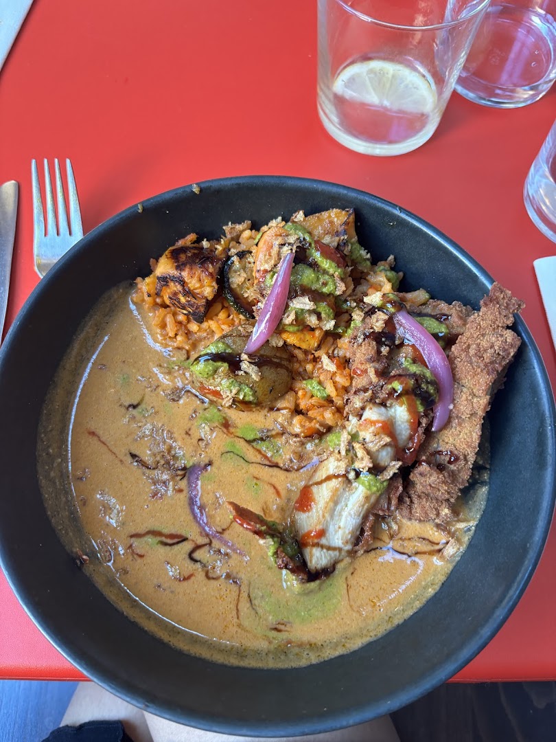 Une assiette généreuse en sauce avec légumes rôtis et oignons roses