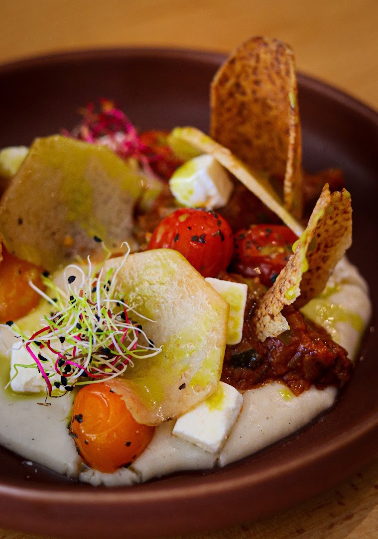 Une assiette colorée de légumes, pousses et éléments croustillants
